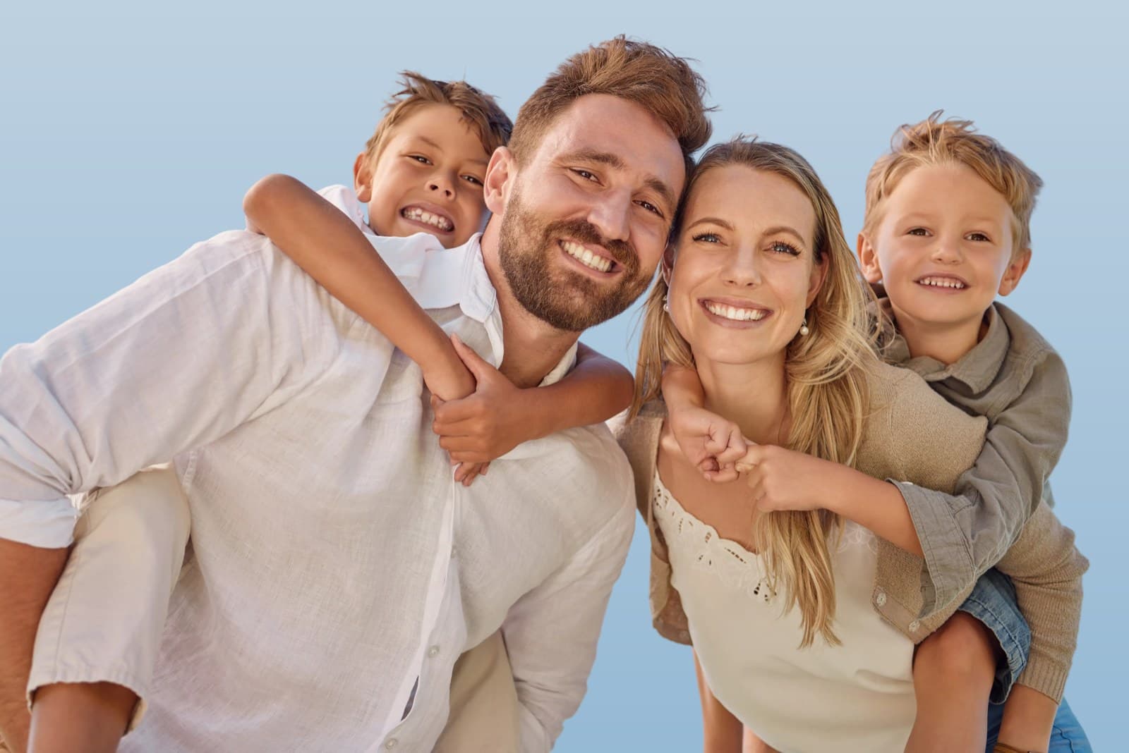A family of four piggybacking outdoors under a clear blue sky, representing whole-family care at ANSA Health Geelong